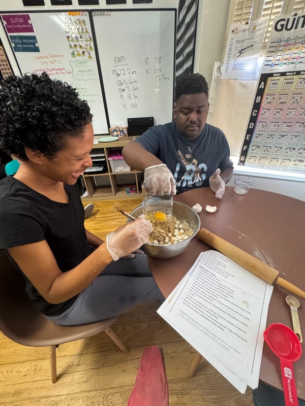 Two adults with disabilities collaborating on mixing and measuring ingredients