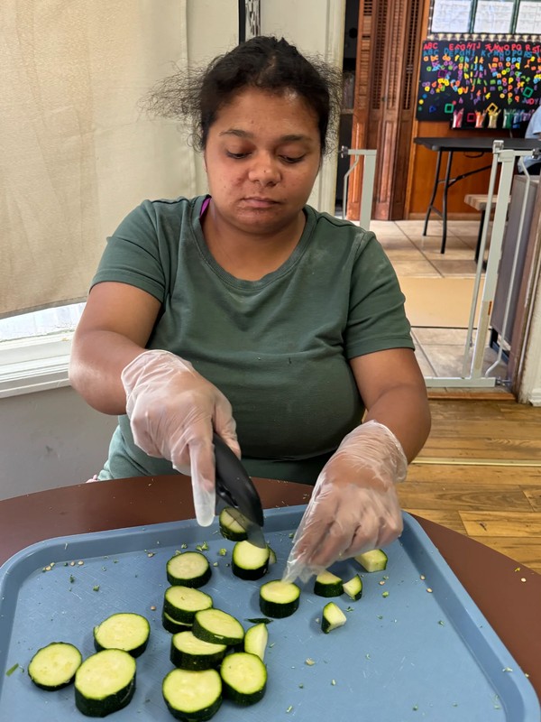 Participant in Ivey's adult day program practicing food preparation