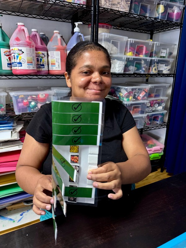 Adult day program participants using visual checklist to manage inventory and restock supplies, developing organizational and task management skills