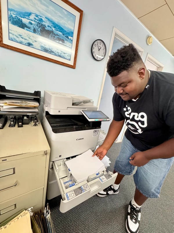 Young adult with disabilities learning office technology skills operating a Canon printer and copier at Ivey Ranch Park Association adult day program