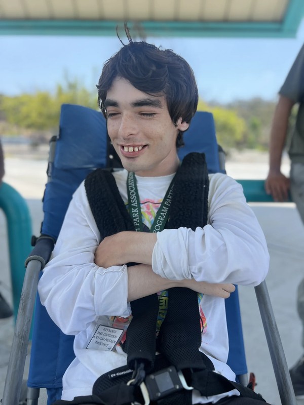 Adult participant enjoying outdoor recreation activity at community park during day program outing