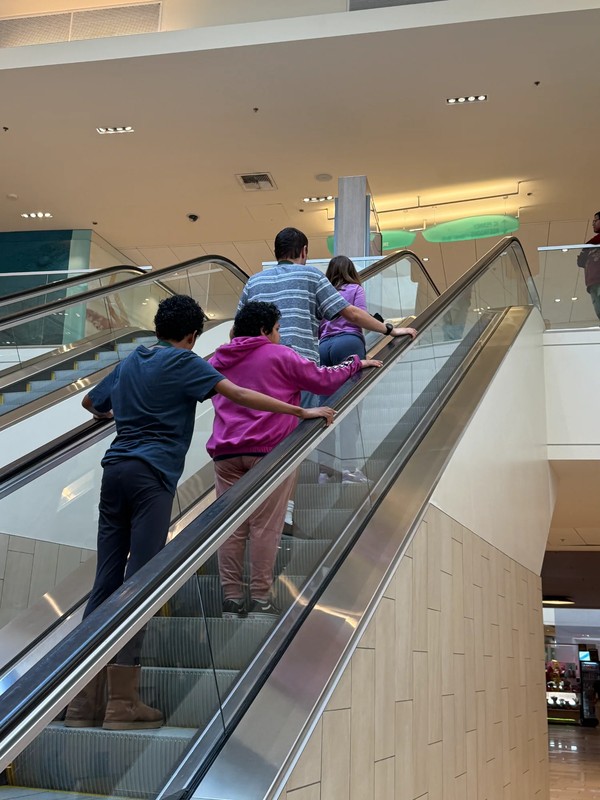 Adults with developmental disabilities learning escalator safety and public space navigation skills at shopping center