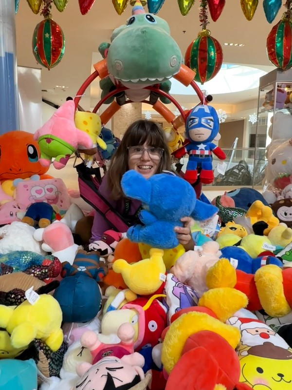 Adult day program participant enjoying recreational arcade game activity during community outing