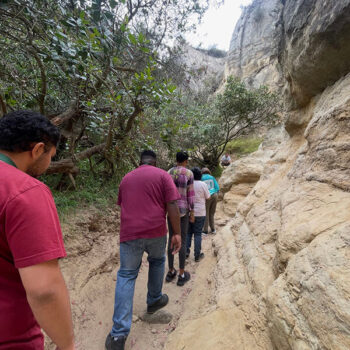 Ivey Ranch Adult Day Program participants hiking through a narrow slot canyon during a community outing