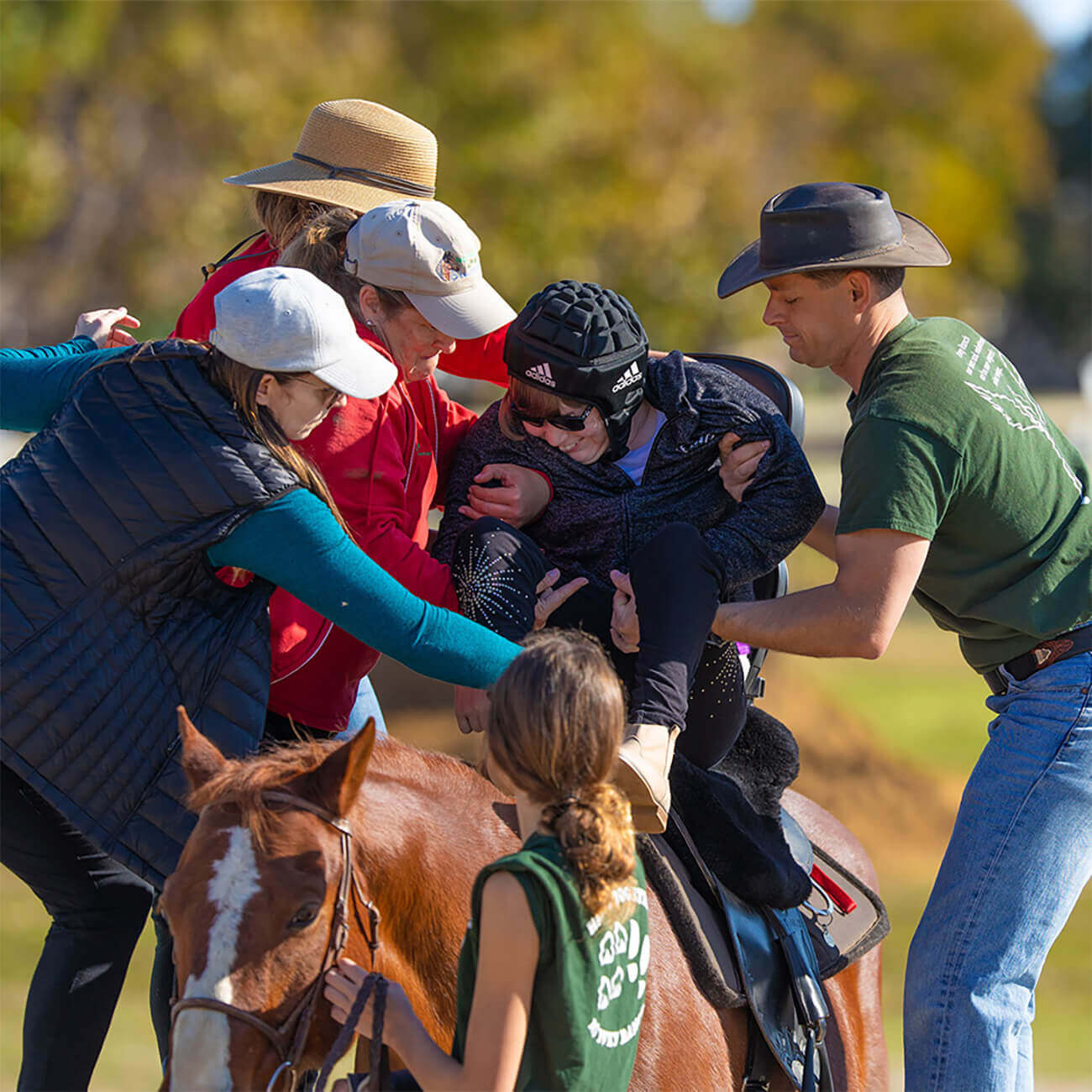 A rider with a disability on horseback during a therapeutic riding session at Ivey Ranch in Oceanside, CA