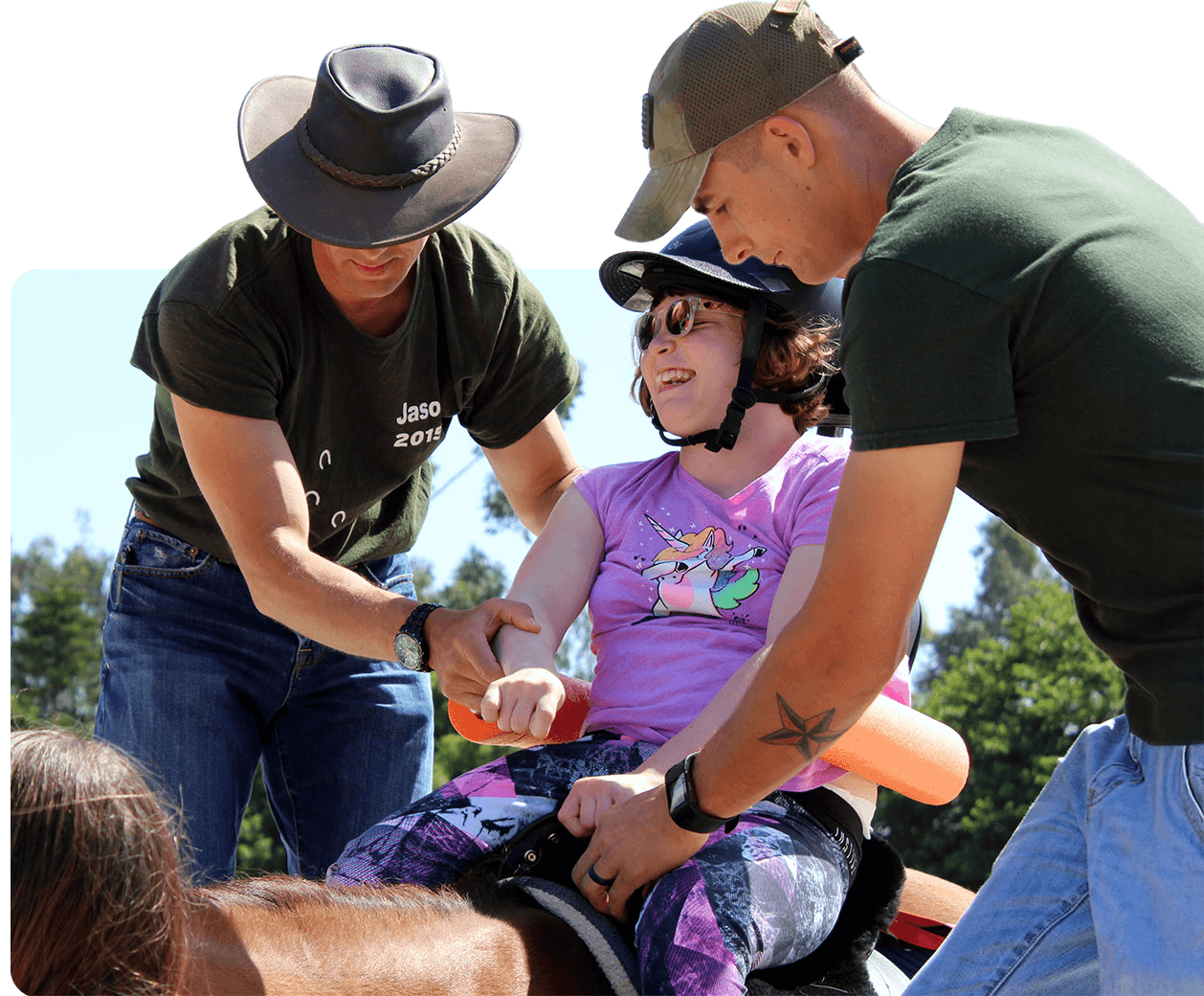 Ivey Ranch volunteers helping a therapy rider get set up to ride, with PATH-certified instructor support