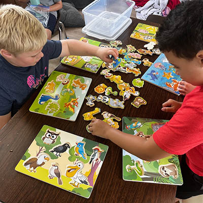 Children working on puzzles together during out-of-home respite care at Ivey Ranch in Oceanside, CA