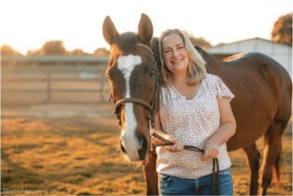 Volunteer Teri standing with retired thoroughbred Island at Ivey Ranch in Oceanside, CA